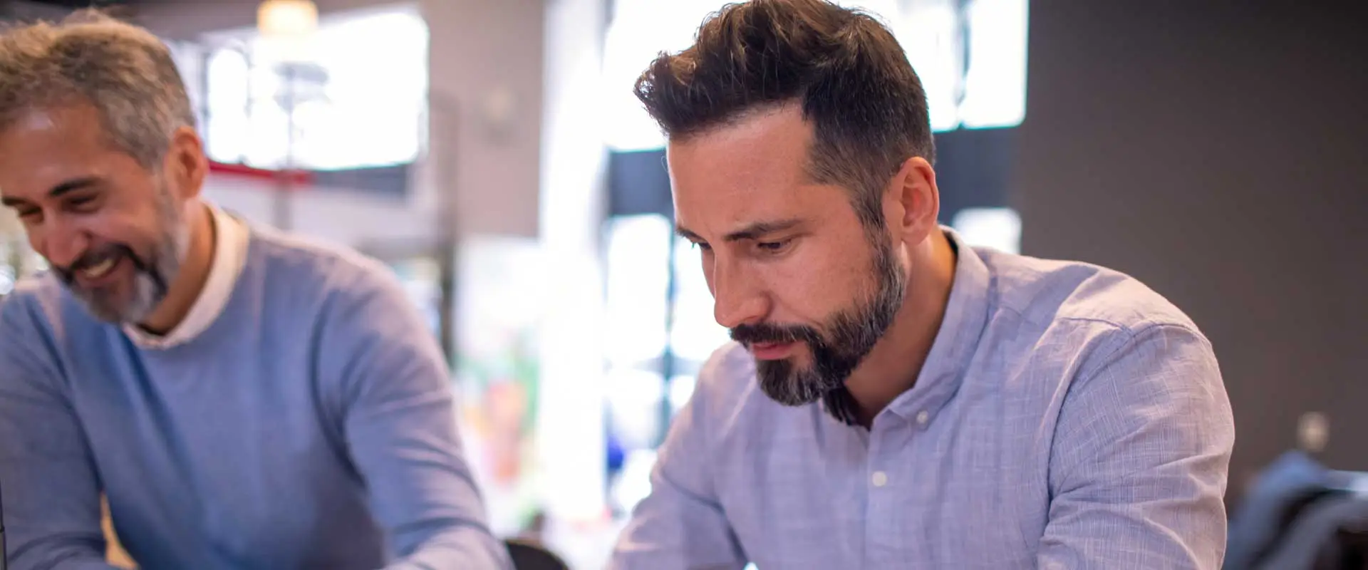 two business partners in casual shirts working together