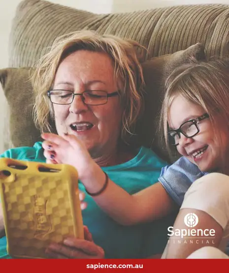 mother and daughter laughing and looking at tablet device