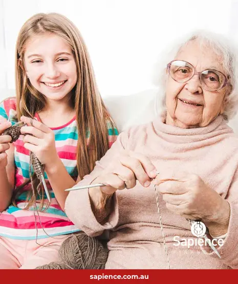 two grandchildren sitting with grandmother on sofa