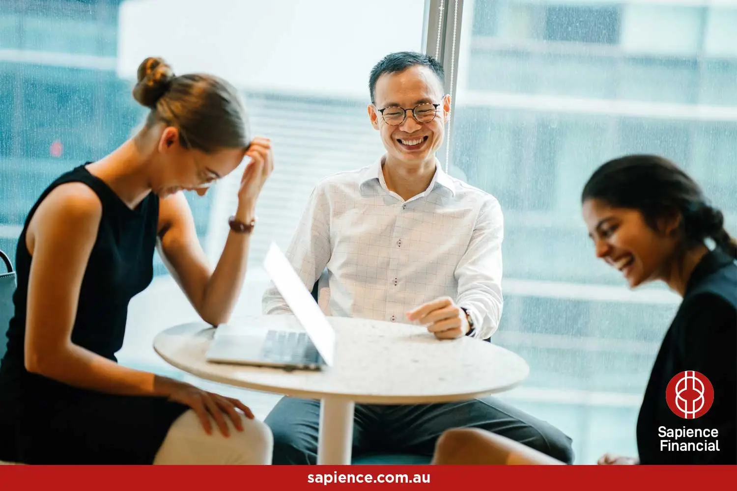 three business friends sitting at a table and laughing and enjoying the moment together