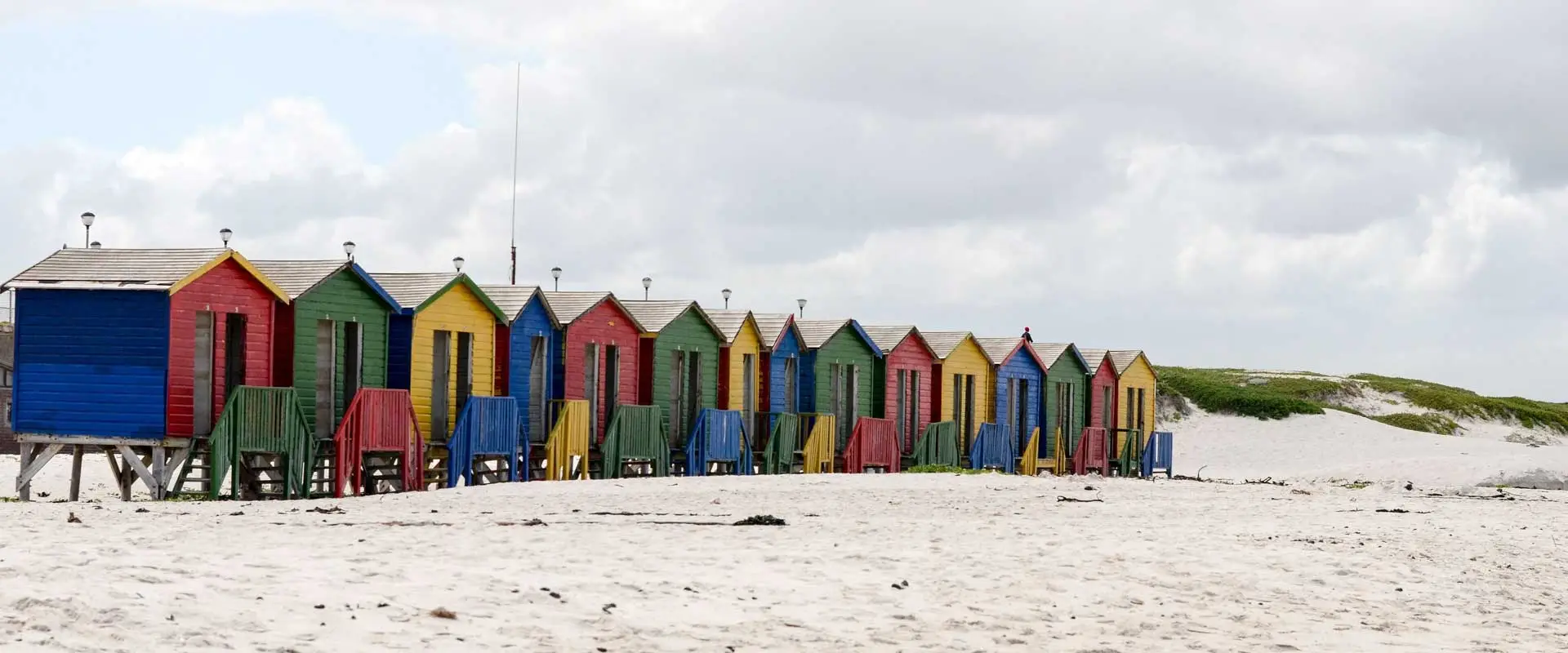 identical beach huts in different colours