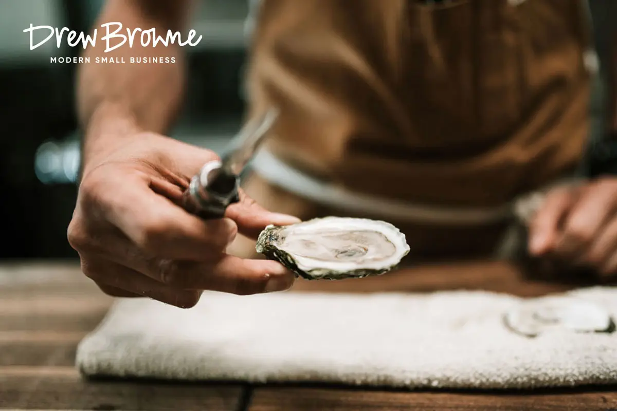 A skilled fishmonger opening an oyster with a knife