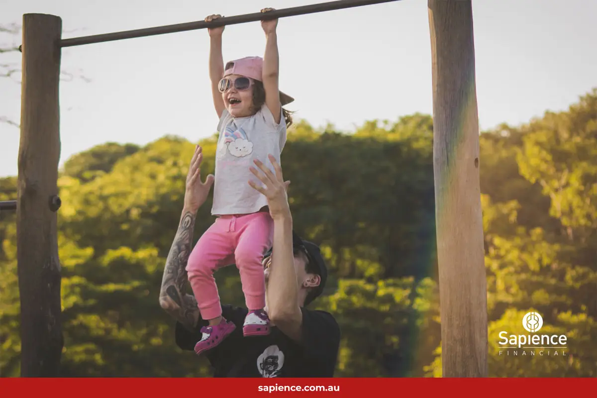 father and child playing on monkey bars