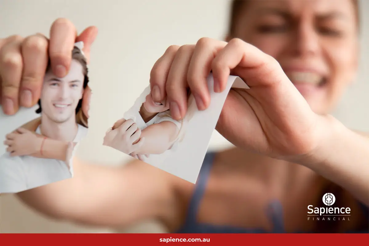 unhappy women tears apart a past photo of her and her partner smiling