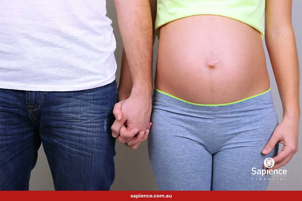 husband and very pregnant wife holding hands
